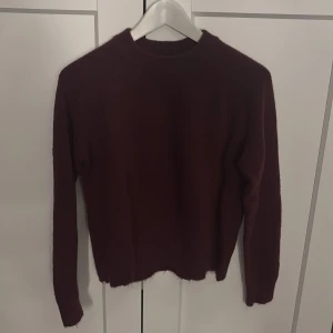 Vinröd tröja - Säljer en stilren vinröd tröja med långa ärmar. Perfekt för kyligare dagar och enkel att matcha med olika outfits. Passar både till vardag och mer uppklädda tillfällen.