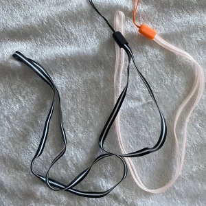Färgglada Halsnöre  - Säljer flera färgglada band i plast. Finns i färgerna svart, rosa, blå, gul och röd. Perfekta för att hänga saker eller som mobiltelefon. Nyckelring, ID kort , USB …….Varje band har en ögla i ena änden för enkel fastsättning.  35kr/2st , helt ny 