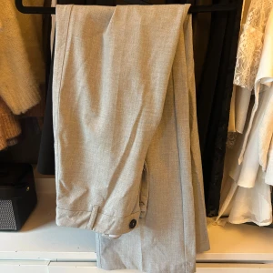 Grå kostymbyxor från Bershka - Snygga grå kostymbyxor från Bershka med en elegant och stilren design. Byxorna har en hög midja och utsvängda ben 