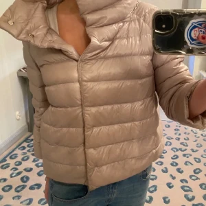 Beige dunjacka från Herno - Säljer en snygg beige dunjacka från Herno. Jackan har en pufferdesign med dragkedja framtill och långa ärmar. Perfekt för kyligare dagar och ger en stilren look. Passar bra till jeans och andra casual outfits.