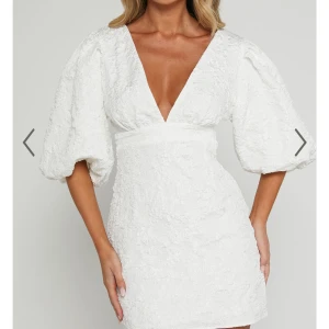 Vit klänning med puffärmar - Intressekoll på en elegant vit klänning från showpo med v-ringning och puffiga trekvartsärmar. Klänningen har en kort längd och en figurnära passform som framhäver midjan. Perfekt för student! Aldrig använd o lappar kvar!🤍