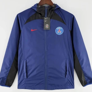 Blå vindjacka från Nike PSG - Säljer en blå vindjacka från Nike med PSG-logga på bröstet. Jackan har svarta detaljer och en röd Nike-logga. Den är utrustad med dragkedja och huva, perfekt för blåsiga dagar.