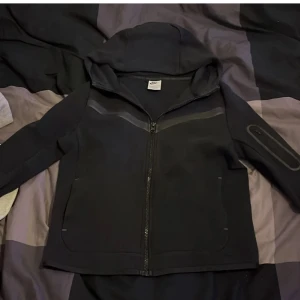 Svart Nike Tech  - Säljer en svart Nike tech eftersom att den inte kommer till användning längre, fin och har inga skador