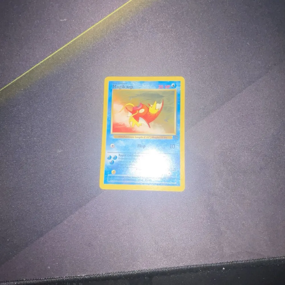 Säljer ett Magikarp Pokémonkort med blå ram och klassisk design. Kortet har en bild av Magikarp i mitten och text med dess egenskaper och attacker, den har lite white spots på sidorna. Perfekt för samlare eller Pokémonfans!. Muu.