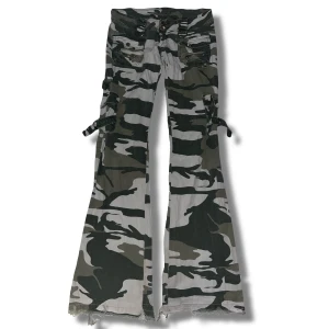 Lågmidjade Crazy Look Camouflage Jeans - Snygga camouflage cargopants med bootcut-stil och coola snörningsdetaljer på sidorna. Väldigt lågmidjade. Inga defekter bortsett från att de är slitna längst ner på byxorna.