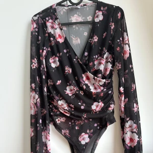 Omlott body  - Blommig omlottbody med ballongärmar.