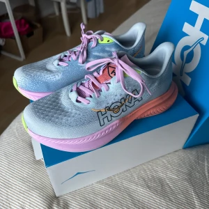 löparskor från Hoka - Säljer ett par färgglada löparskor från Hoka. Modellen heter W MACH 6. De är otroligt lätta på foten och en toppen löparsko, jag säljer då jag köpte fel storlek. Storlek: 39 1/3, nypris 2000kr. Helt nya och endast testade!
