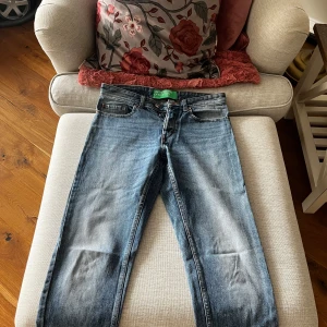 Blå jeans från United Colors of Benetton - Snygga blå jeans från United Colors of Benetton med klassisk femficksdesign och knappgylf. Perfekta för en avslappnad stil. 