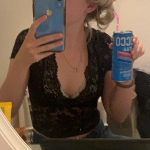 Svart spetsblus - Säljer en elegant svart spetsblus med korta ärmar och v-ringning. Perfekt för en kväll ute eller en speciell tillställning. 