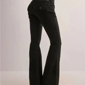 Svarta bootcut jeans från True Religion - Snygga svarta bootcut jeans från True Religion med klassiska femficksdesign och knappar på bakfickorna. Perfekta för en stilren look med en touch av retro. Passar bra till både sneakers och klackar. De passar i längden till nån som e 165-167cm