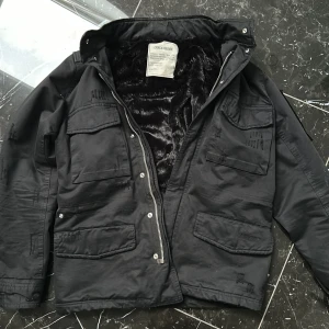 Svart jacka från Zadig & Voltaire - Säljer en svart jacka från Zadig & Voltaire med flera fickor och dragkedja. Jackan har en mjuk foder och är perfekt för kyligare dagar. Den har en stilren design med knappar och detaljer på ärmarna.