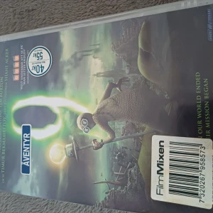 9 - DVD av filmen '9', ett animerat äventyr från Focus Features. Omslaget visar en karaktär i en postapokalyptisk miljö med en lysande stav. Filmen är regisserad av Shane Acker och har en speltid på 76 minuter. Den är textad på svenska och rekommenderas från 11 år.