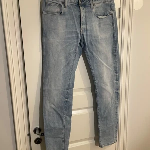 Ljusblå jeans från G-Star RAW - Snygga ljusblå jeans från G-Star RAW, modell 3301 Slim. De har en klassisk femficksdesign och en slim passform som ger en modern look. Perfekta för en stilren vardagsstil.