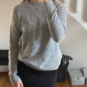 Grå stickad tröja med rund hals - Mysig grå stickad tröja med rund halsringning och långa ärmar från lager 157. Tröjan har en enkel och stilren design med ribbade muddar vid ärmslut och nederkant. Perfekt för svala sommarkvällar, passar xs-s 🌸