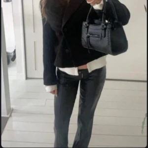 Svarta skinnbyxor med rak passform - Snygga svarta skinnbyxor med rak passform och låg midja. Byxorna har en glansig finish och klassisk dragkedja framtill. Perfekta för dig som vill ha en edgy och trendig look.