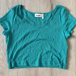 Turkos ribbad croppad topp Weekday - Säljer en turkos ribbad croppad topp från Weekday. Toppen har korta ärmar, rundad halsringning och är tillverkad i mjuk bomull. Perfekt för dig som gillar en enkel men snygg stil.