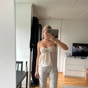 Beige axelbandslös tubtopp med spets - Söt beige tubtopp med bandeau-överdel och broderad spets nertill. Köpt på plick för ett tag sedan, aldrig använts utav mig. 
