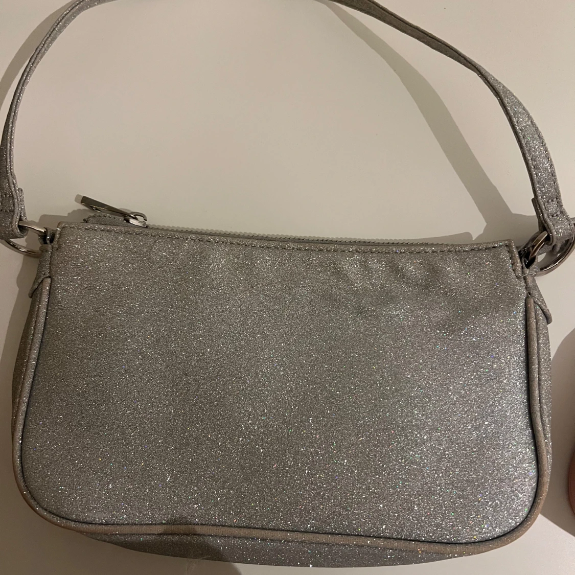 Glittrig silver axelväska