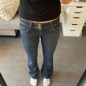 Lågmidjade jeans - Lite använda lågmidjade utsvängda vintage jeans med brodering på fickorna, lite slitna längst ner men annars bra