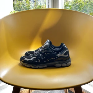 asics gel nyc graphite grey( storlek 44 passar även 43) - Snygga Asics sneakers i svart och grått med meshpaneler och detaljer i syntet. Skorna har rund tå, snörning och en rejäl, mönstrad sula för bra grepp. Perfekta för dig som gillar sportig stil och vill ha bekväma skor till vardagen.