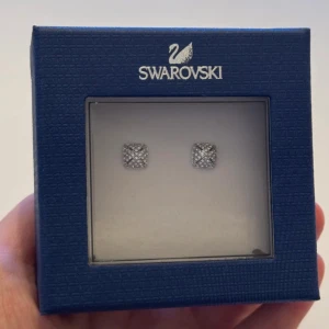 Swarovski glittriga örhängen i silver - Kvadratiska örhängen från Swarovski i silverfärg, täckta med små gnistrande kristaller för en riktigt lyxig känsla. Kommer i originalask med äkthetsbevis. Perfekta för dig som vill ha något stilrent men ändå glittrigt.