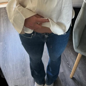  jeans med låg midja bikbok - Säljer ett par klassiska blå jeans med bootcut och låg midja från bikbok i storlek xs 31 