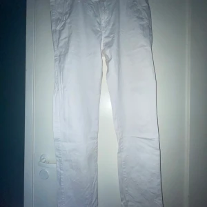 Vita chinos från Indicode Jeans - Snygga vita chinos från Indicode Jeans med klassisk passform och raka ben. Byxorna har sidfickor, bakfickor med knapp och stängs med knapp och dragkedja. Perfekta för en clean och fräsch look. Tillverkade i bomull för skön känsla.