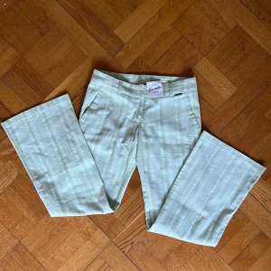 Mintgröna randiga byxor från Decade - Snygga mintgröna byxor från Decade med diskret randigt mönster. Byxorna har raka ben/bootcut. Tillverkade i ett lätt material som känns fräscht och passar perfekt till vår och sommar. Jättebra skick med prislapp kvar!!