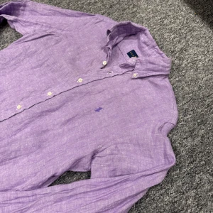 Ralph Lauren linneskjorta (Krobbes) - Snygg lila skjorta från Ralph Lauren i 100% linne. Klassisk button-down krage, långa ärmar och vita knappar framtill. Broderad logga på bröstet i matchande lila. Perfekt för en chill och stilren look. Size small men passar Medium. Krobbe worn! 459kr +frakt Välmött, BB!🍾