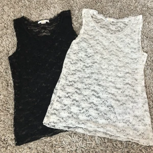 KÖP INTE DIREKT! (Båda för 200, 1 för 120)  - Två ärmlösa linnen i spets, ett svart och ett vitt. Båda har blommigt spetsmönster och rund halsringning. Perfekta att ha under en t-shirt eller som de är för en snygg lager-på-lager-look.