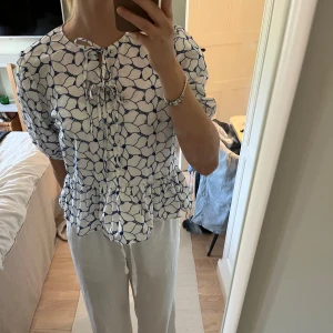 Sommarblus från Lindex - Säljer en vit/blå sommarblus med knyte på framsidan. Den är från Lindex och är i storlek M. Blusen är i luftig o skön att ha på sig. Den är knappt använd o i mycket bra skick. Jag får tyvärr ingen användning för den och vill därför sälja den vidare. 