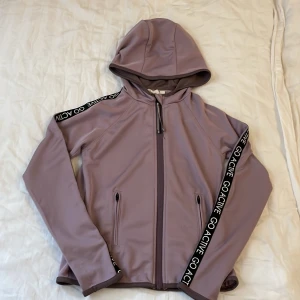 Lila sportsjacka från Kappahl - Fin lila sportsjacka från Kappahl i stl 134-140. Bra att ha när det är lite kallt innan och efter träningen tex. 