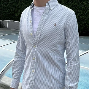 Randig skjorta från Ralph Lauren - Blå-randig Ralph Lauren skjorta 👔 Storlek S ✅ Skjortan är i nyskick 🆕  Pris går diskuteras🤝 Hör av er vid frågor eller om ni behöver fler bilder:)