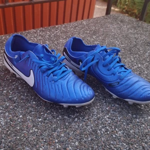 Nike Legend 10 Pro fotbollsskor "testade endast 1 gång" 1 gång - Nike Legend 10 Pro FG fotbollsskor i en snygg blå färg med vita och svarta detaljer. Skorna har snörning, rund tå och platt sula med fasta dobbar för spel på naturgräs. Ovandelen är i syntetmaterial och designen är sportig och modern. Jag har bara använt de 1 gång för att testa de men de passade inte tyvärr. Nypris 1849 kr. Pris kan såklart diskuteras fråga på om ni har frågor!