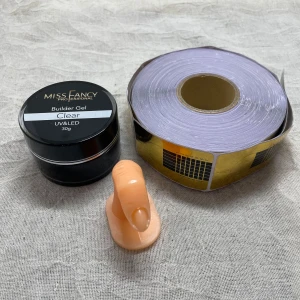 Startkit - Miss Fancy Builder Gel Clear 30g - Builder Gel Clear från Miss Fancy, 30g, perfekt för att bygga och forma naglar med UV/LED-lampa  Gelen är transparent och kommer i en svart rund burk. Medföljer gör även nagelformar på rulle (ca 100st) och ett övningsfinger i plast för träning av nagelteknik. ⚠️Har testat formulan