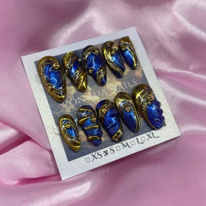 Midnight (S);Medium Almond - Snygga press-on naglar i storlek S: 15 mm, 11,5 mm, 12 mm, 11 mm, 9 mm, med glittrig blå cateye bas, detaljer i metallic guld och små guldfärgade pärlor. Naglarna har är unika , och special designade. Perfekt för dig som vill sticka ut med en kreativ och lyxig nageldesign.