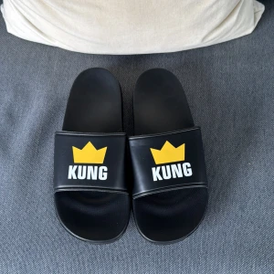 Svarta tofflor med KUNG-tryck - Kung tofflor i storlek 40-41. Aldrig använda, säljs inte längre😊 