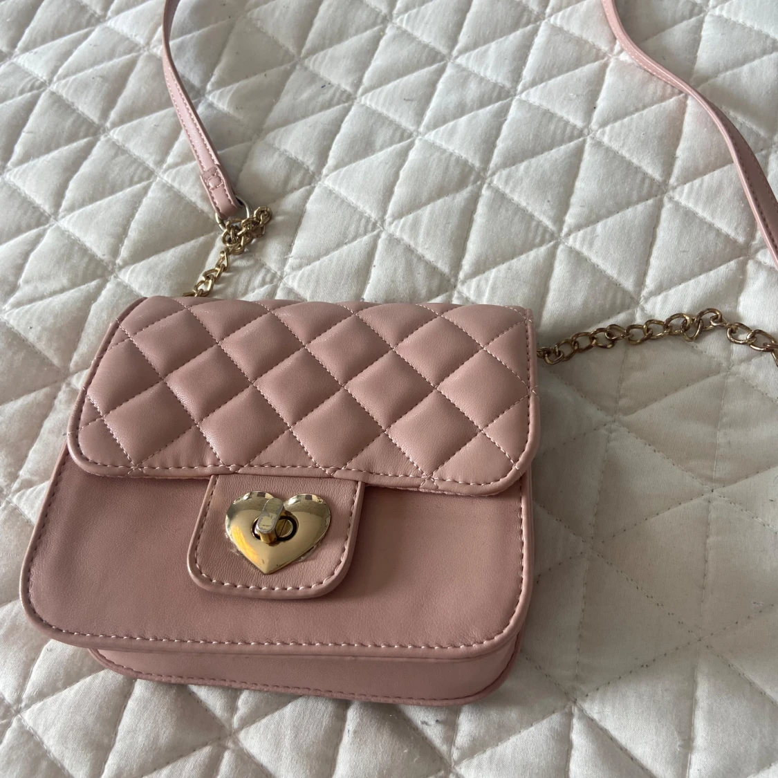 Rosa quiltad axelväska med hjärtspänne