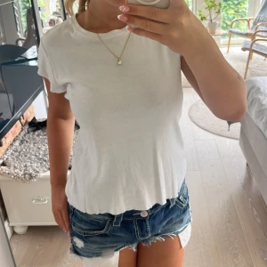 Vit basic t-shirt från ZARA - En klassisk vit t-shirt från ZARA i mjuk bomull. Modellen är kortärmad med rund halsringning och har en clean, enkel look som passar till allt. Perfekt för dig som gillar en stilren vibe och vill ha en skön tisha till sommaren.