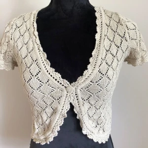 Bolero - Söt bolero från indiska. Beige med glittrig tråd i. Längd ca 45cm.