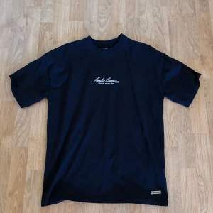 Svart oversized t-shirt Black Squad - Svart oversized t-shirt från Black Squad med vit text och coolt tryck på ryggen med en röd orm och texten 'HELL N BACK'. Framtill står det 'Infinite' på en metallbricka vid fållen. Skön bomullskvalitet och korta ärmar. 