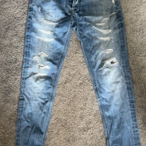 Dondup Jeans - Riktigt schyssta jeans som är en riktig komplimang-magnet🤩🤩😮‍💨😮‍💨 De är ett par ljusblå skinny jeans med slitningar och hål på framsidan. Jeansen har klassisk femficksdesign och är tillverkade i denim med en snygg tvättad look.  