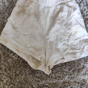 Beige shorts från Pull&Bear XS - Säljer ett par ljusbeige shorts från Pull&Bear i storlek XS. De har elastisk midja och är tillverkade i mjuk bomull, perfekta för varma dagar. Modellen är loose fit och har en enkel, stilren look utan mönster eller detaljer.