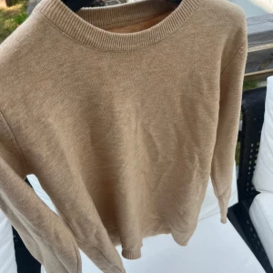 Beige merinoull sweatshirt - En stilren beige stickad tröja med rund halsringning. Tröjan är helt ny inprincip, aldrig andvänd endast legat i garderoben. Storlek S eller XS