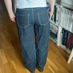 Randiga blå byxor med vita ränder från Only - Säljer ett par blå byxor med smala vita ränder. Byxorna har raka ben och stora bakfickor. De har en avslappnad, loose stil. Perfekta för dig som gillar en chill och trendig look. Finns även matchande skjorta till 💖