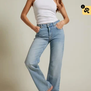 Ljusblå wide jeans från bikbok - Säljer ett par ljusblå jeans från bikbok med hög midja och raka, vida ben. Har vanligtvis w27 och dessa är i w32 för en baggy look. Klassisk femficksmodell i mjukt denimtyg med bälteshällor och knappgylf. Perfekta för en avslappnad och trendig look. 