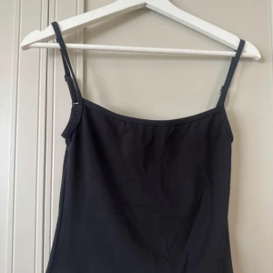 Svart träningstopp från LXA - Svart träningstopp från LXA med smala, justerbara axelband. Toppen är figurnära.. Använd 1 gång