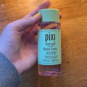 Pixi Rose Tonic toner 100 ml - Pixi Rose Tonic är en ansiktstoner med ros och fläderblom som återfuktar och lugnar huden. Kommer i en mintgrön plastflaska med skruvlock och rosa vätska. Perfekt för dig som vill ha en fräsch och återfuktad känsla i ansiktet. Aldrig använd helt ny, postar snabbt!