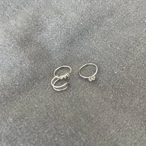 Näspiercings - Säljer tre näspiercings i silverfärg. Superfina att byta mellan då alla ger det lilla extra: en av de ser ut som en dubbelring och de andra har stenar i olika former. Det går även att använda stenarna för att göra egna smycken. Självklart tvättade!🌸