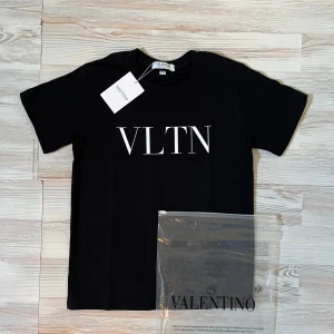 Svart t-shirt från Valentino VLTN - Svart t-shirt från Valentino med VLTN-tryck i vitt på bröstet. Klassisk rund halsringning och korta ärmar. Tillverkad i mjuk bomull för en skön känsla och clean look. Perfekt för dig som gillar stilrena designer och exklusiva märken.